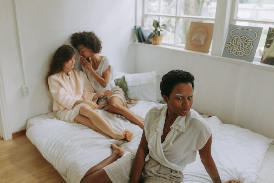 Three women relaxing in a cozy bedroom, enjoying togetherness and privacy.
