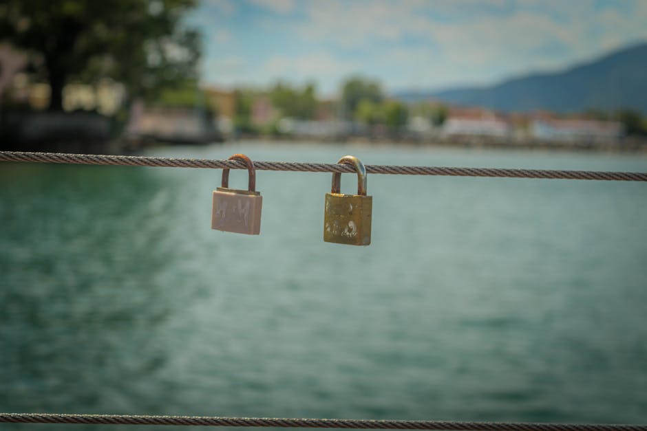 A pair of love padlocks on a railing, symbolizing enduring romance against a serene water backdrop.