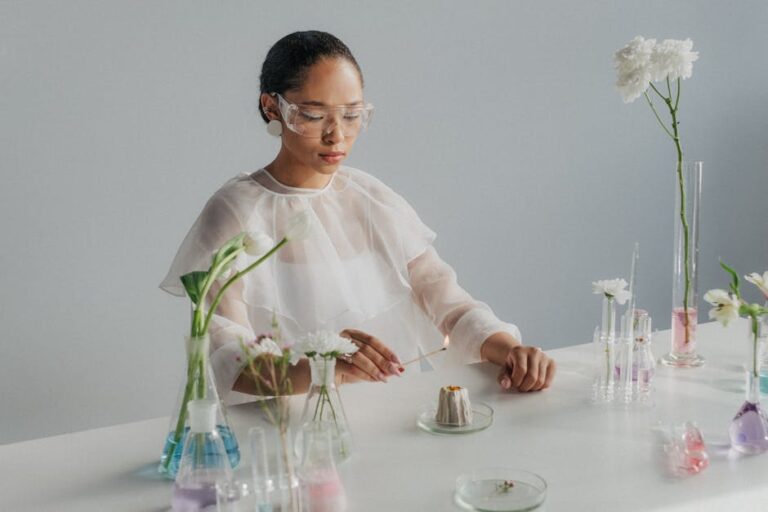 Scientist experimenting with flowers and glassware, blending science and nature in a studio setting.