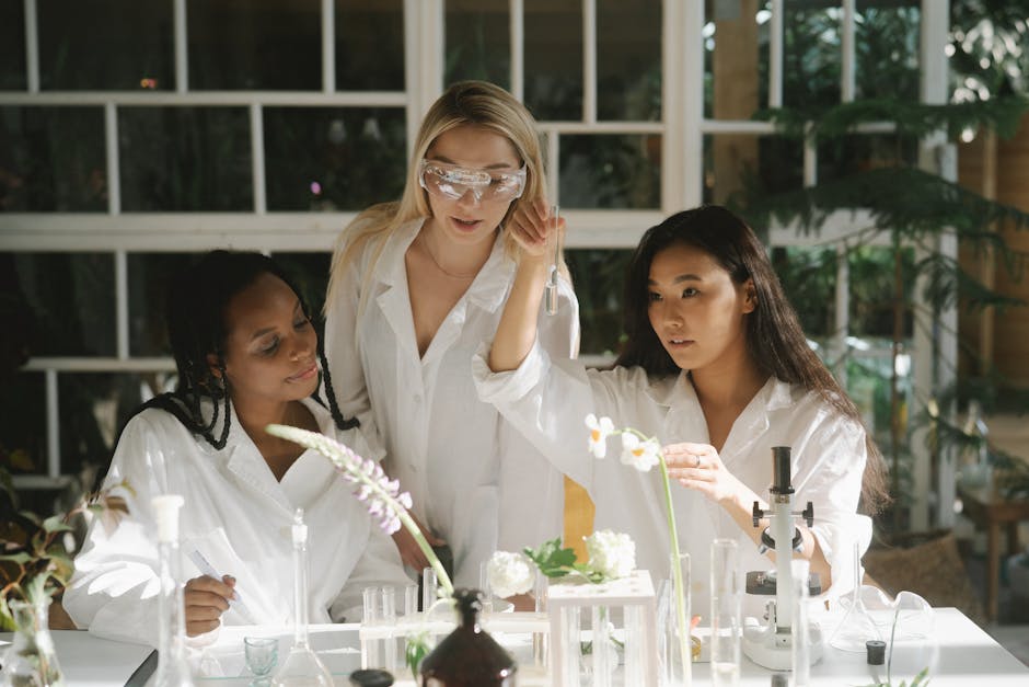 Three women scientists in a lab examining plants and using various laboratory equipment.