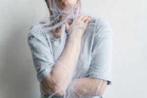 A woman metaphorically trapped in a spider web depicting anxiety and entrapment.