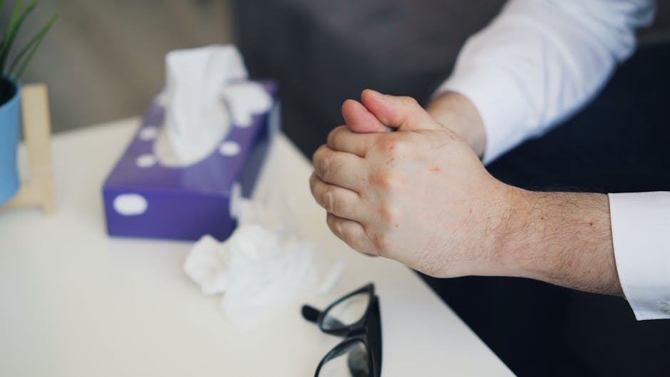 Hands nervously clasped near a tissue box, suggesting emotional stress or therapy session.