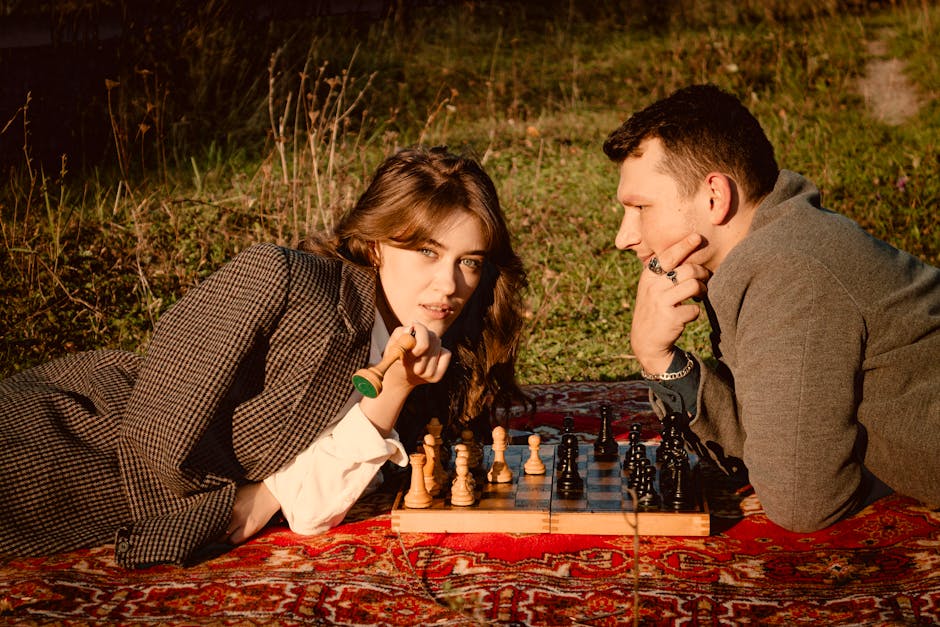 A fashionable duo plays chess in a rural meadow, blending strategy and style.