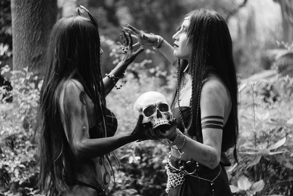 Two women engaged in a mystical ritual holding a skull in a forest.