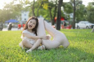 Happy child sitting on grass with a balloon, celebrating outdoors in Bắc Ninh, Vietnam.