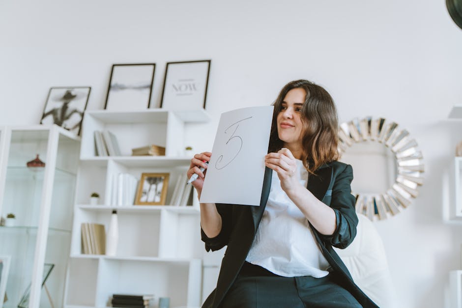 Woman in black blazer holds paper with number five, smiling in modern office setting.