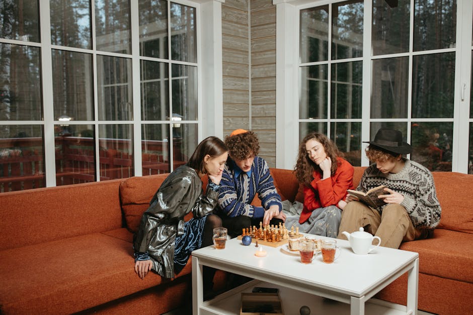 Friends playing chess and reading indoors, creating a cozy and focused atmosphere.