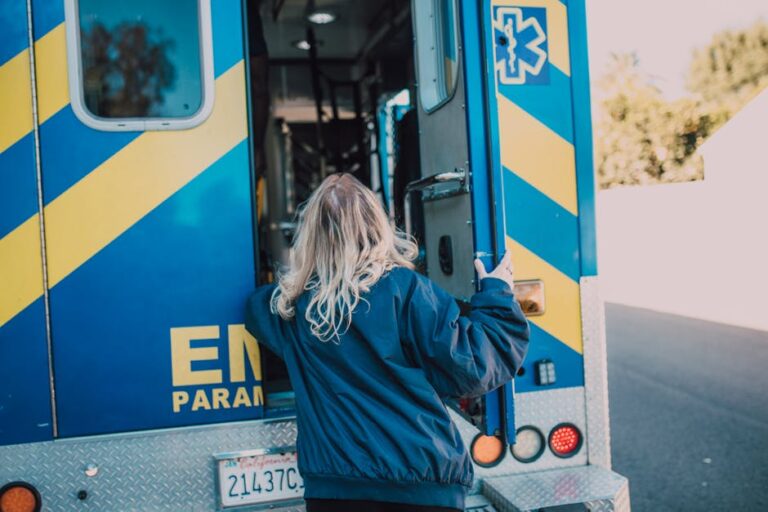 A woman in a navy jacket boarding an ambulance, showcasing emergency services in action.