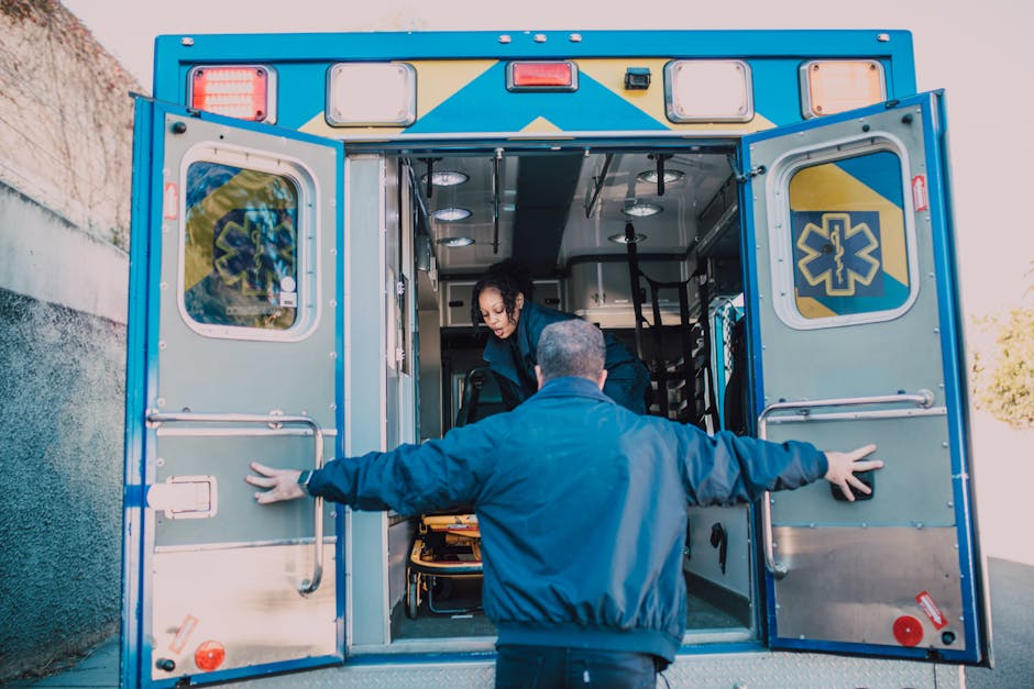 Paramedics load equipment into an ambulance, readying for an emergency call.