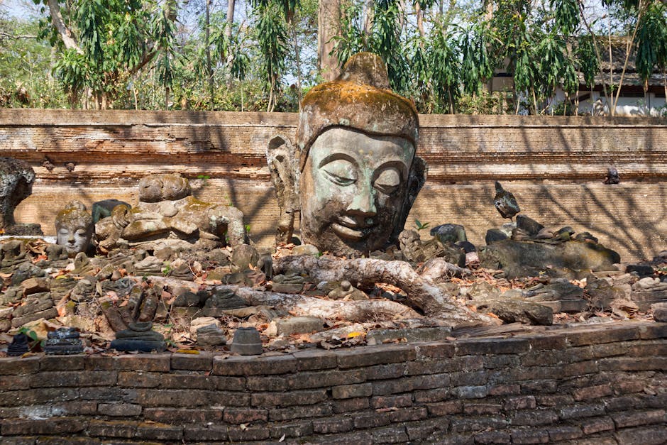 A serene Buddha head amidst ancient bricks and ruins in Chiang Mai, Thailand.