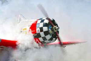 A T-6 Texan propeller airplane surrounded by smoke during takeoff in Titusville, Florida.