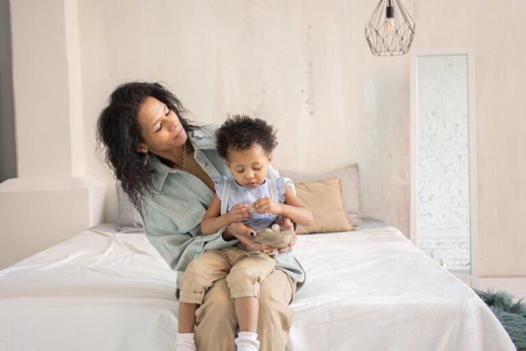 A mother and her child enjoying a tender moment on a bed in a modern, cozy bedroom.