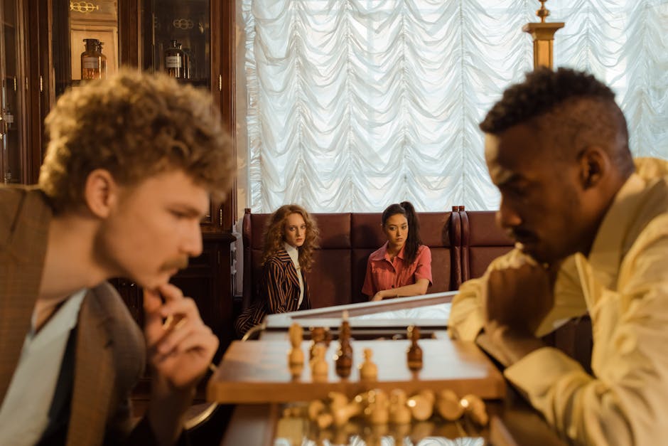 A group of diverse adults intensely watching a chess game indoors, depicting focus and strategy.