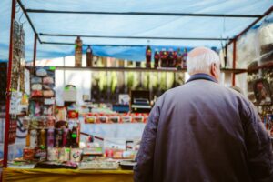 Senior adult browsing an outdoor market stall in Buenos Aires, Argentina.