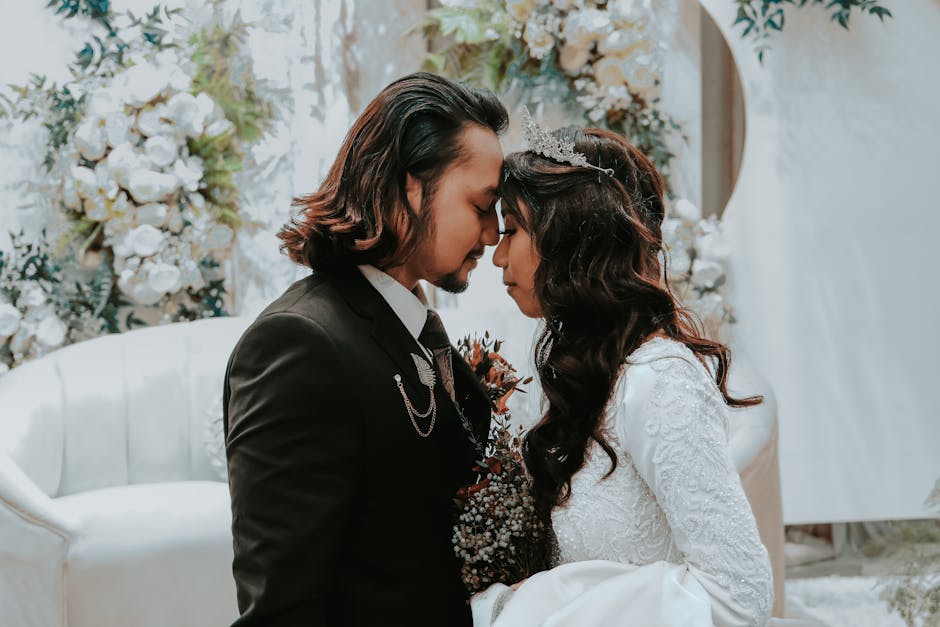 Elegant wedding photo featuring a bride and groom in a tender moment surrounded by floral arrangements.