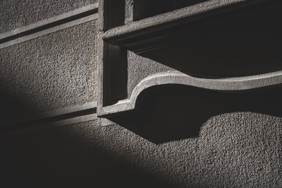 Dramatic shadows on a textured concrete wall create urban contrast.