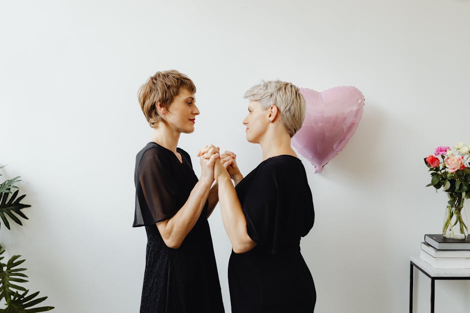 A tender moment between a loving lesbian couple holding hands indoors with a romantic setting.