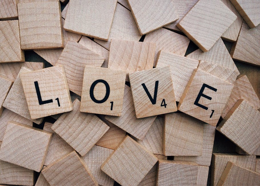 Scrabble tiles arranged to spell 'love' on a wooden background, conveying affection.