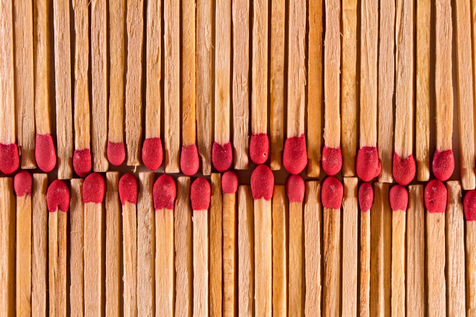 Top view of thin wooden matches with red flammable heads placed in rows as abstract background
