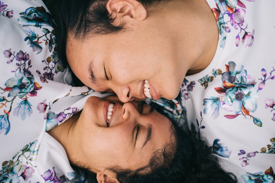 A loving couple smiling face-to-face in matching floral outfits, expressing affection and happiness.
