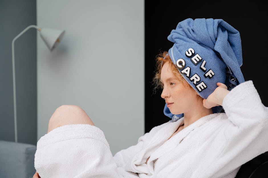 Relaxed woman in a bathrobe with a towel headwrap featuring 'self care' letters enjoying a moment at home.