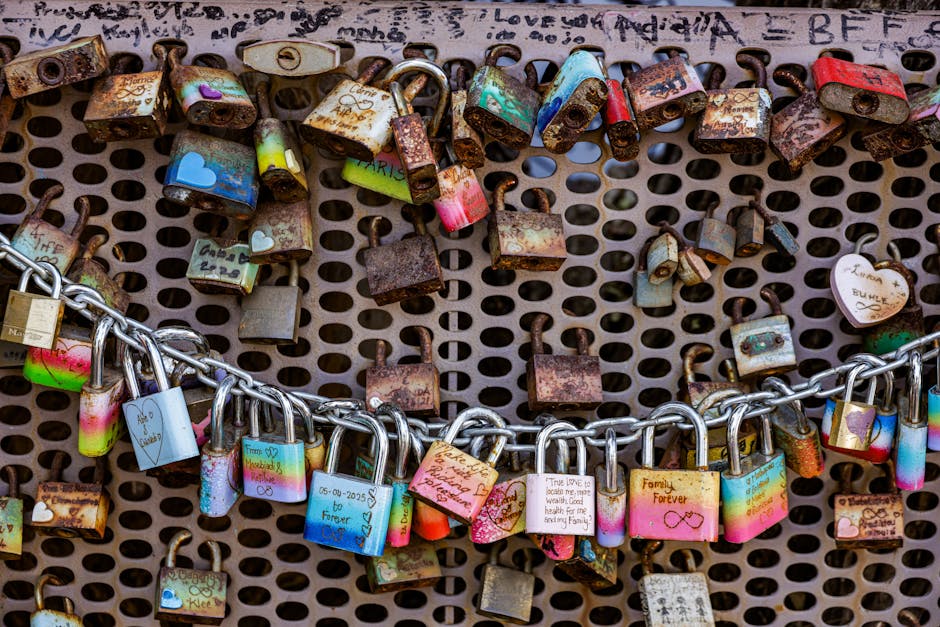 Rusty and colorful love padlocks attached to a bridge fence in Paris symbolizing everlasting love.