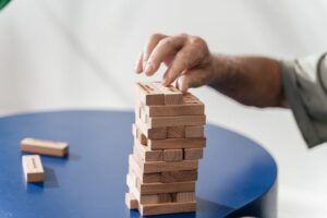 Close-up of a man's hand playing a game of Jenga, focusing on skill and precision.