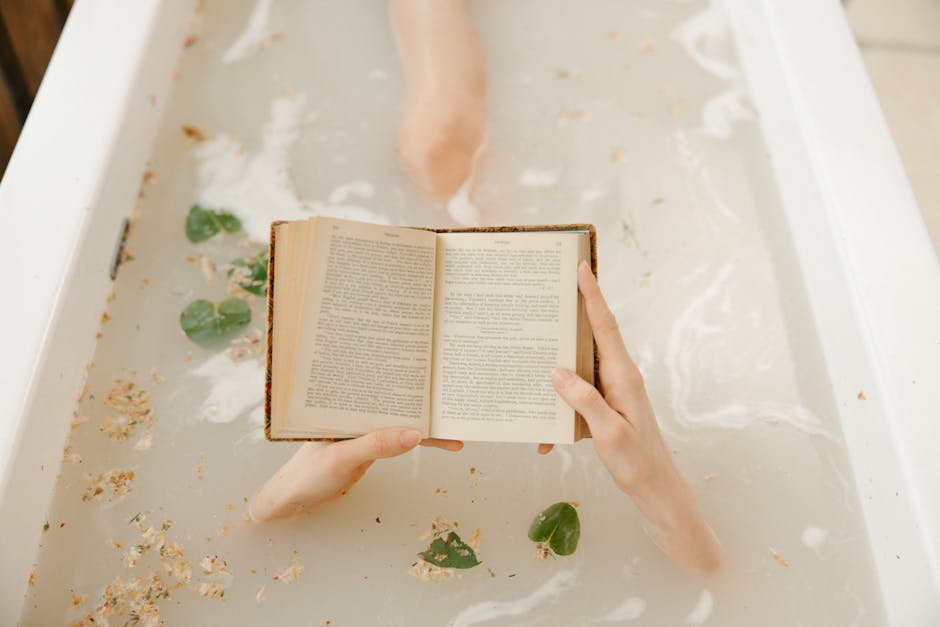 A calming scene of reading a book in a bathtub with petals floating, ideal for relaxation themes.