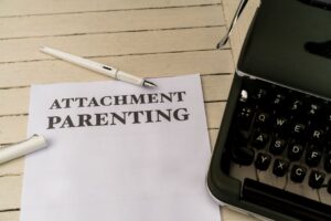 Vintage typewriter and paper with 'Attachment Parenting' text on wooden desk.