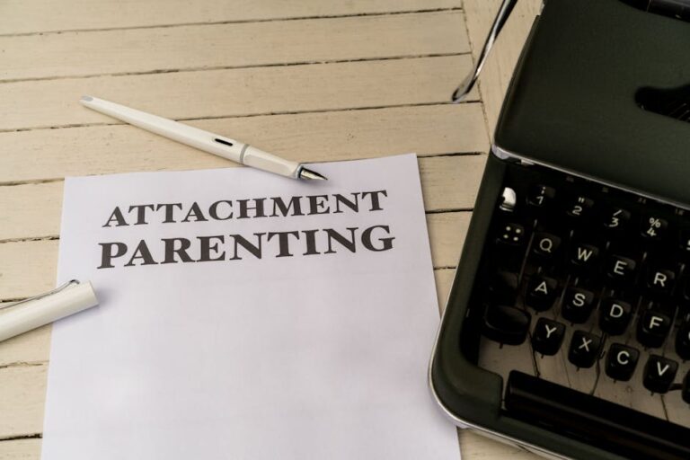 Vintage typewriter and paper with 'Attachment Parenting' text on wooden desk.