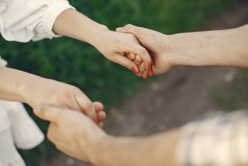 A couple holding hands in an outdoor setting symbolizing love and unity.
