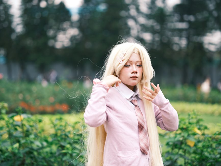 A young cosplayer dressed in pink with long blonde hair posed outdoors. Vibrant and artistic scene.