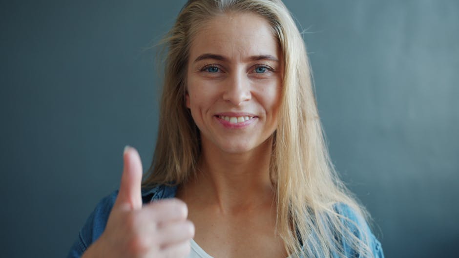 Confident woman with a thumbs up gesture, showing positivity and agreement.
