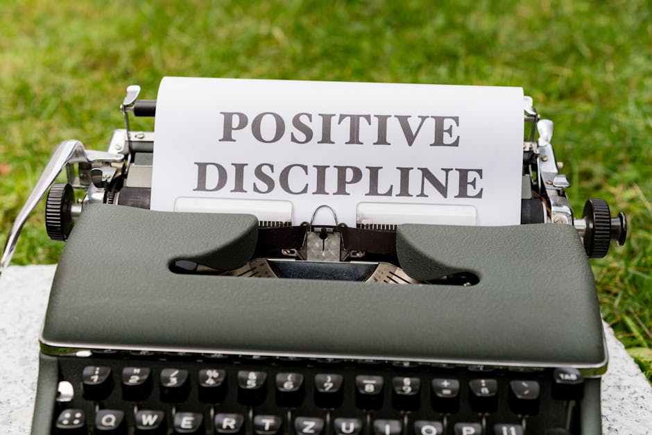 A vintage typewriter outdoors with paper showing 'Positive Discipline'.