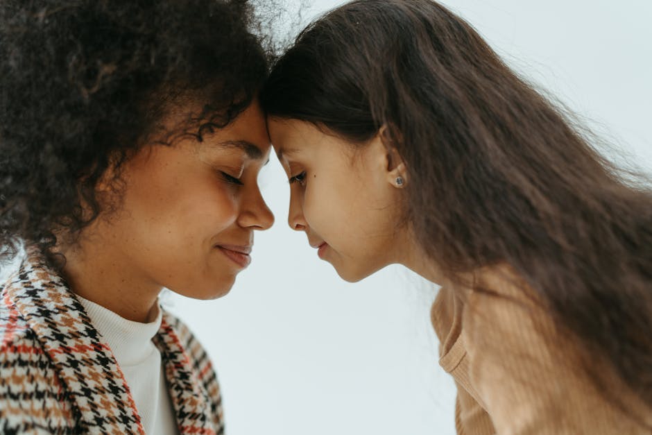 A close-up portrait of a loving mother and daughter sharing a tender moment.