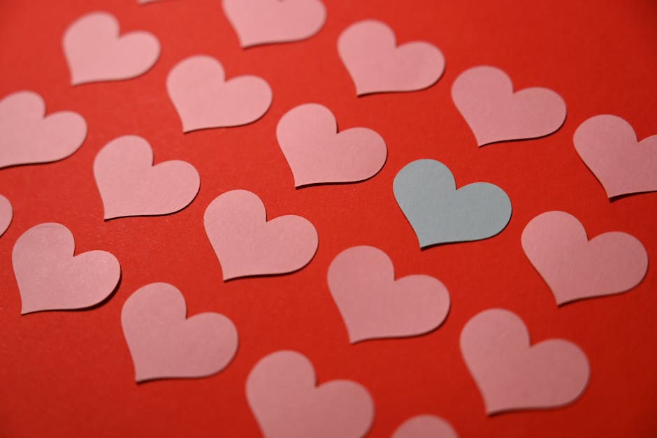 A collection of pink and blue paper hearts on a vibrant red background.