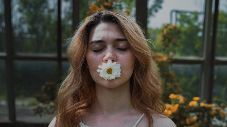 A woman with closed eyes holds a white flower in her mouth, surrounded by lush greenery.