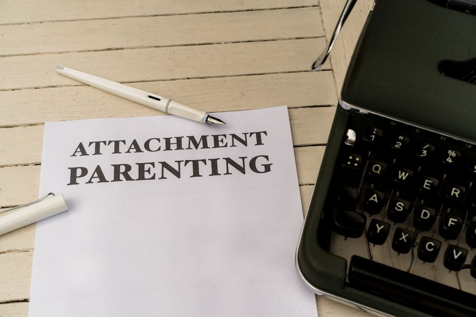 Vintage typewriter and paper with 'Attachment Parenting' text on wooden desk.