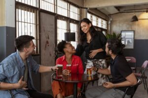 A group of friends sharing drinks and laughter at an indoor cafe.