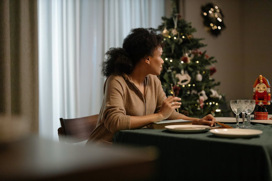 Black woman enjoying a quiet Christmas Eve dinner by a decorated tree, feeling festive and cozy.