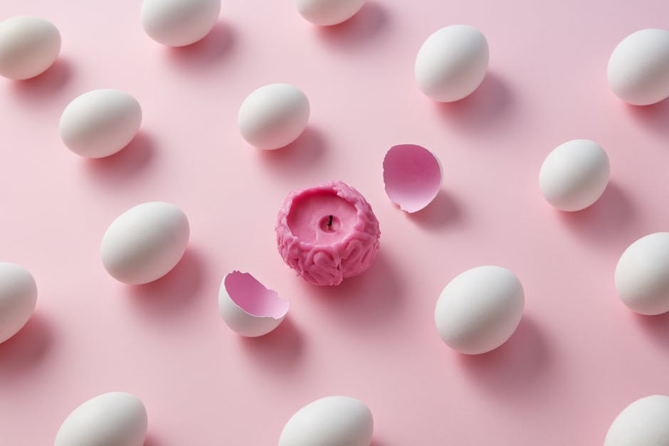 A unique pink brain-shaped candle surrounded by white eggs on a light pink backdrop, depicting creativity and contrast.