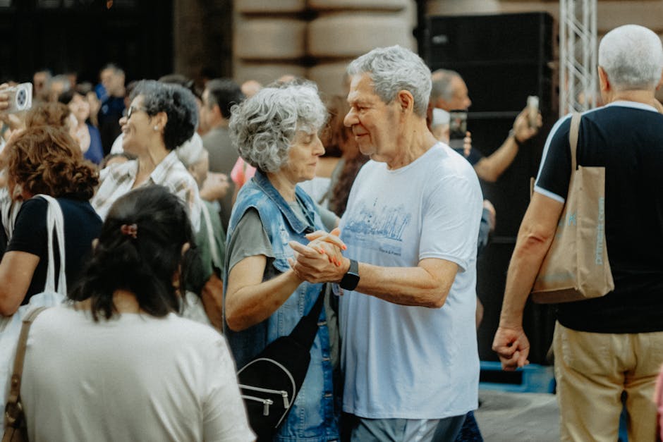 Senior couple dancing joyfully at an outdoor gathering, celebrating life and connection.