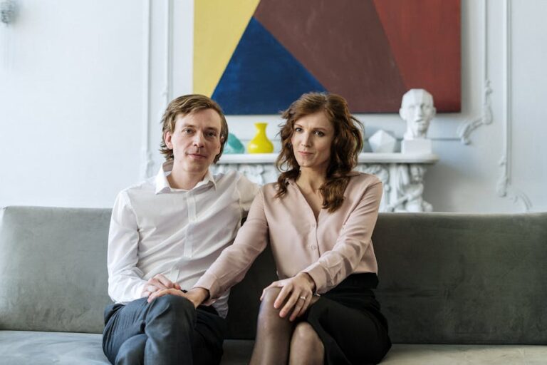A couple sitting on a couch during a counseling session, showing connection and support.