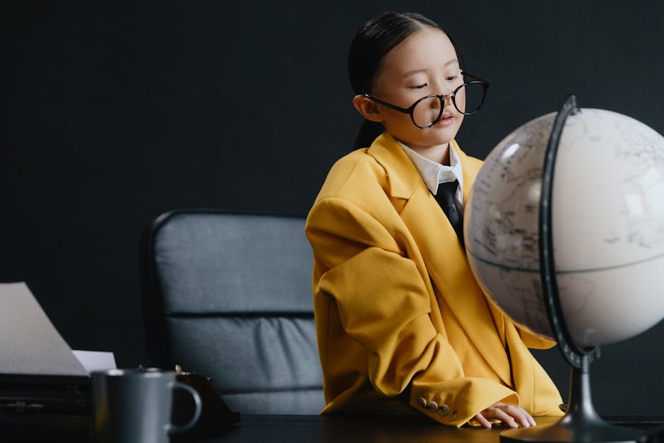Young girl in yellow suit explores a globe, inspiring curiosity and education.