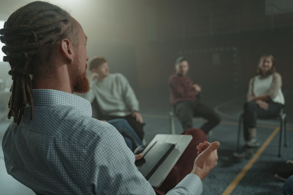 A group of adults engaged in a casual discussion indoors, focusing on communication and interaction.