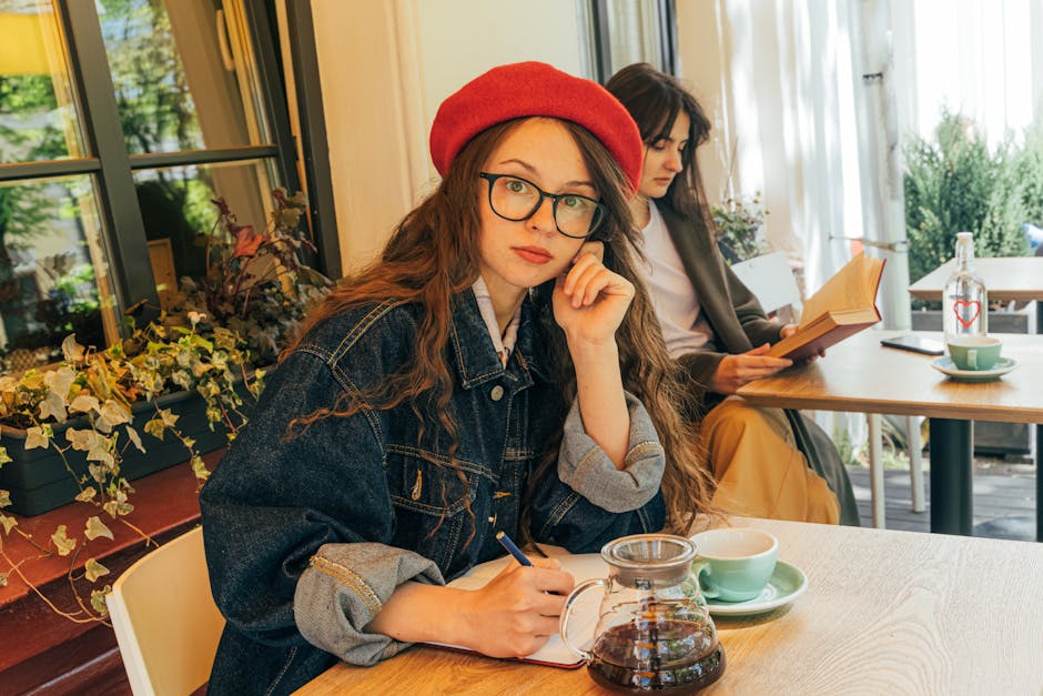 Two women enjoying a cozy café setting, engaged in writing and reading activities.