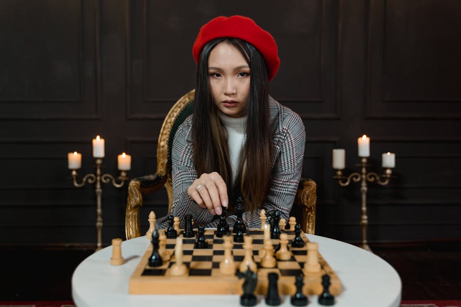 A woman in a beret focuses on a chess match indoors, surrounded by candles for ambiance.