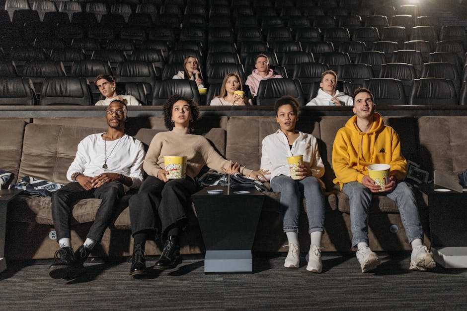 A diverse group of people enjoying a suspenseful movie scene in a theater.