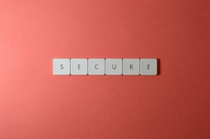 A close-up of the word 'Secure' spelled out with tiles on a red surface, ideal for security concepts.