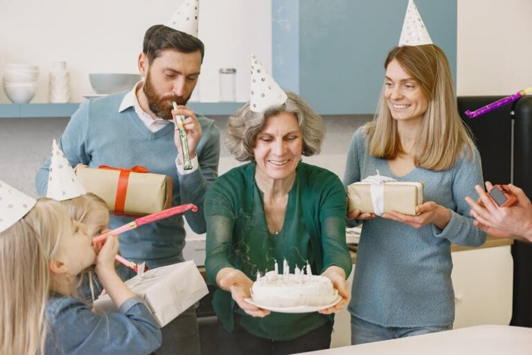 A happy family celebrating with gifts, cake, and party hats indoors, showcasing togetherness and joy.